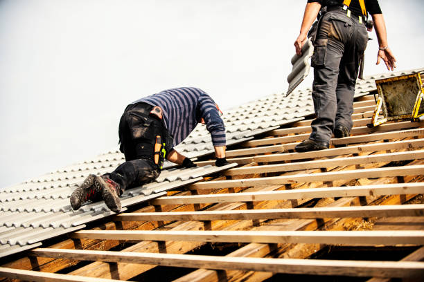 A person wearing safety goggles and a long sleeved shirt while cutting a metal roofing sheet