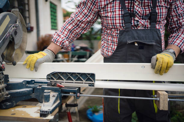 A person using adjustable clamps to secure a metal roofing sheet to a workbench